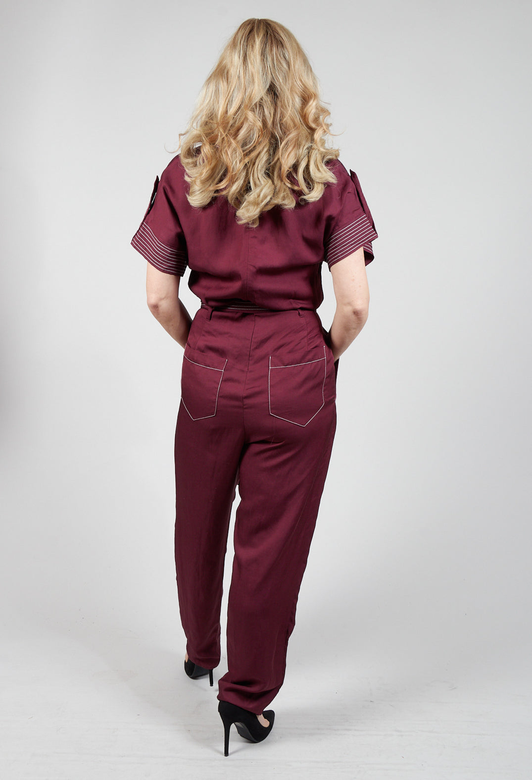 behind shot of burgundy Beatrice B jumpsuit with pockets and tie waist belt