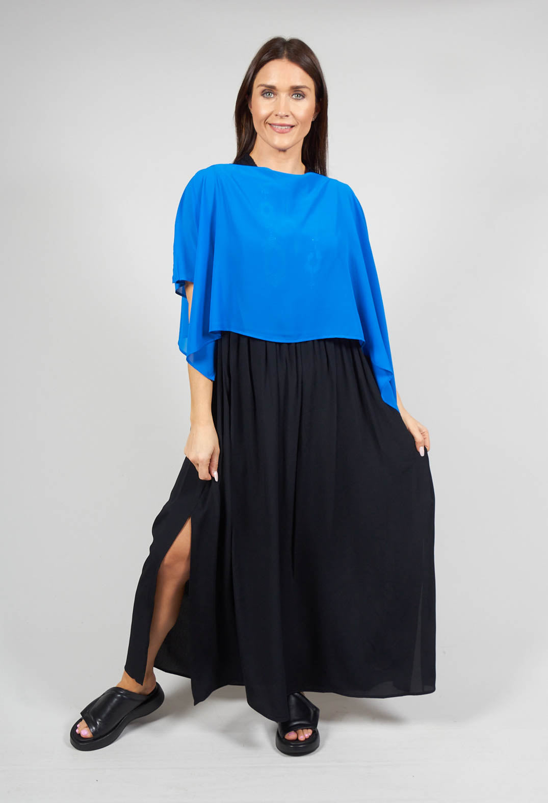 lady smiling and wearing a cover up with waterfall sleeves in blue