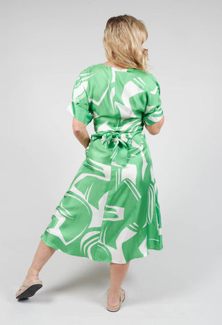 behind shot of Beatrice B wrap over silk dress in green with tie waist belt
