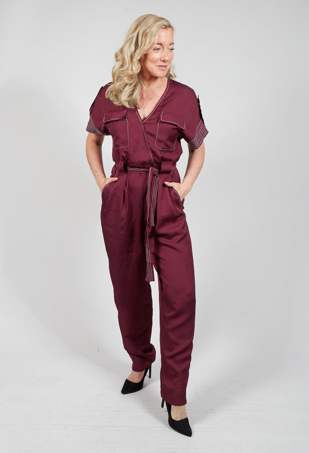 lady wearing a burgundy jumpsuit with waist tie belt