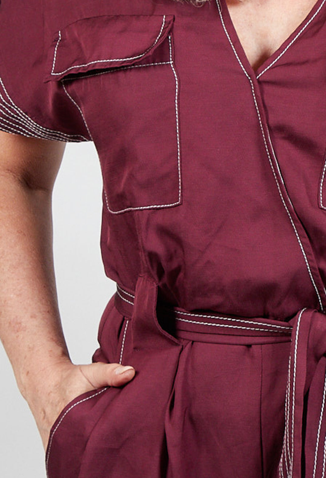 close up of burgundy Beatrice B jumpsuit with tie waist belt