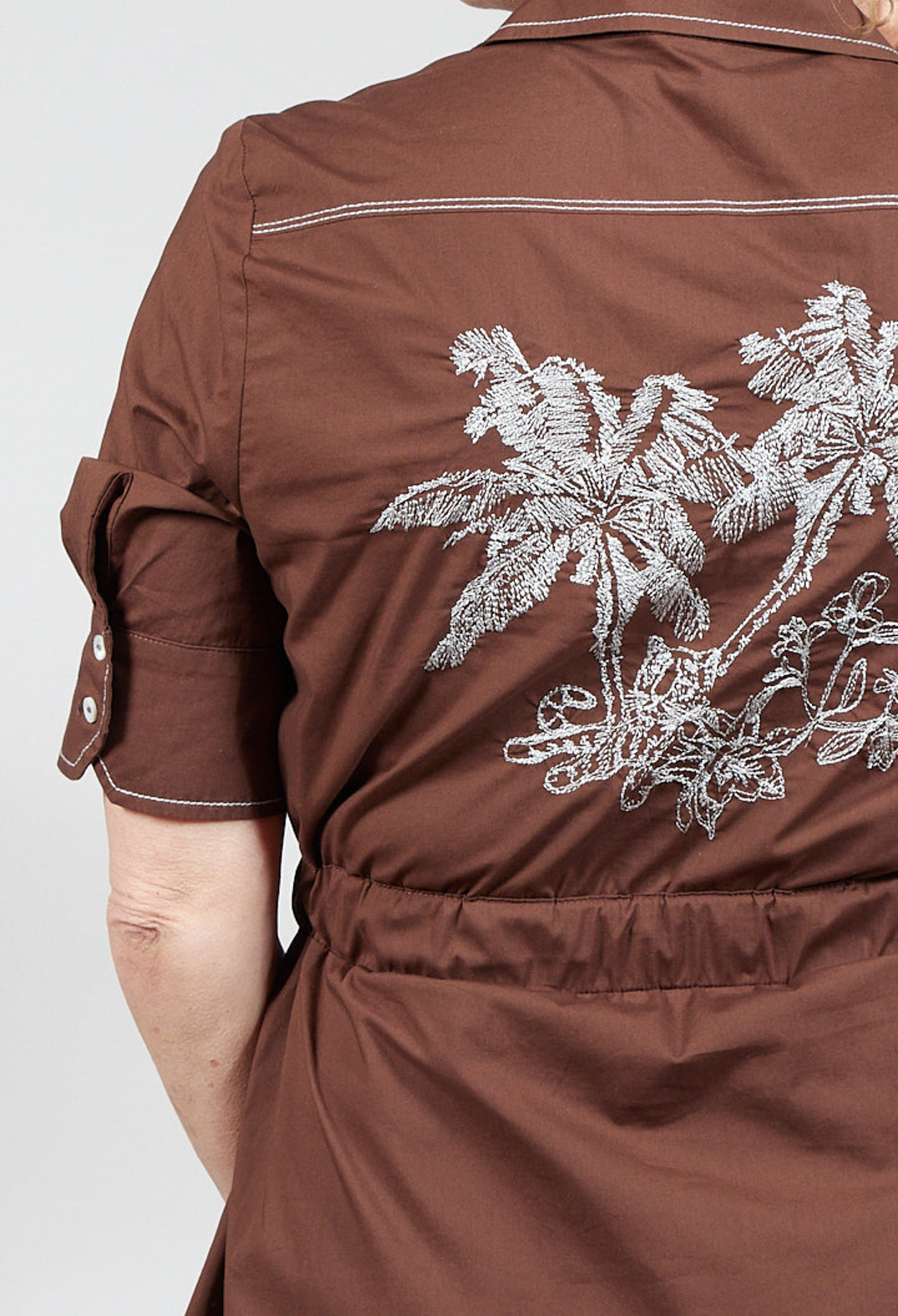 embroidery detail on a brown shirt dress