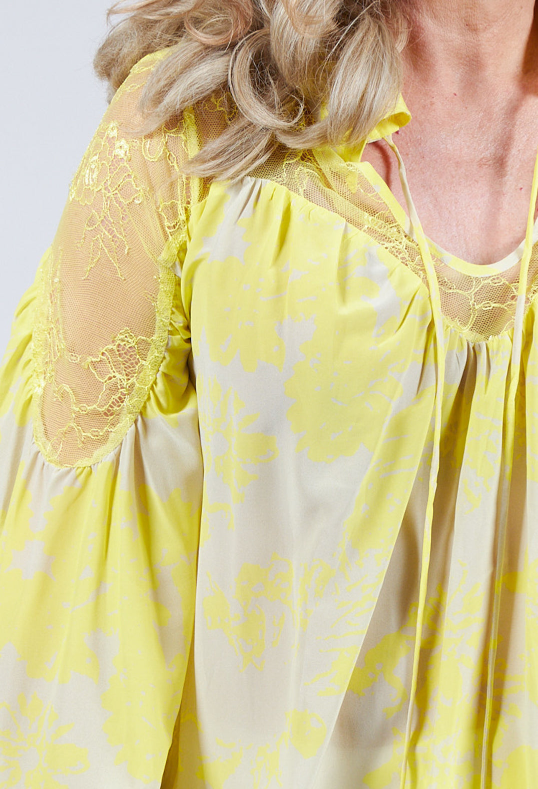 close up of lace detail blouse in cream with neck string tie