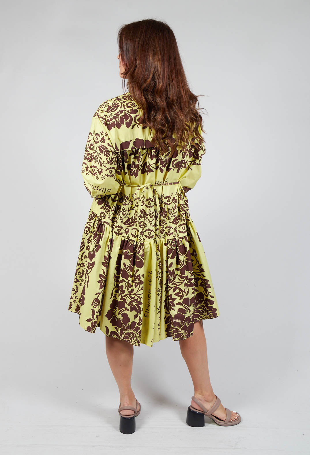 behind shot of lady wearing a long sleeved shirt dress in tahiti print