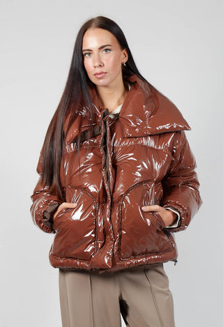 lady wearing a rao jacket in shiny brown with side pockets and button fastening