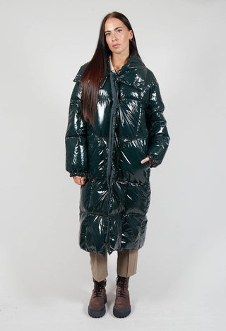 lady wearing a dark green rave coat, light trousers and chunky brown boots