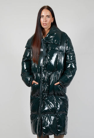 lady wearing a dark green rave coat with her hands in the side pockets