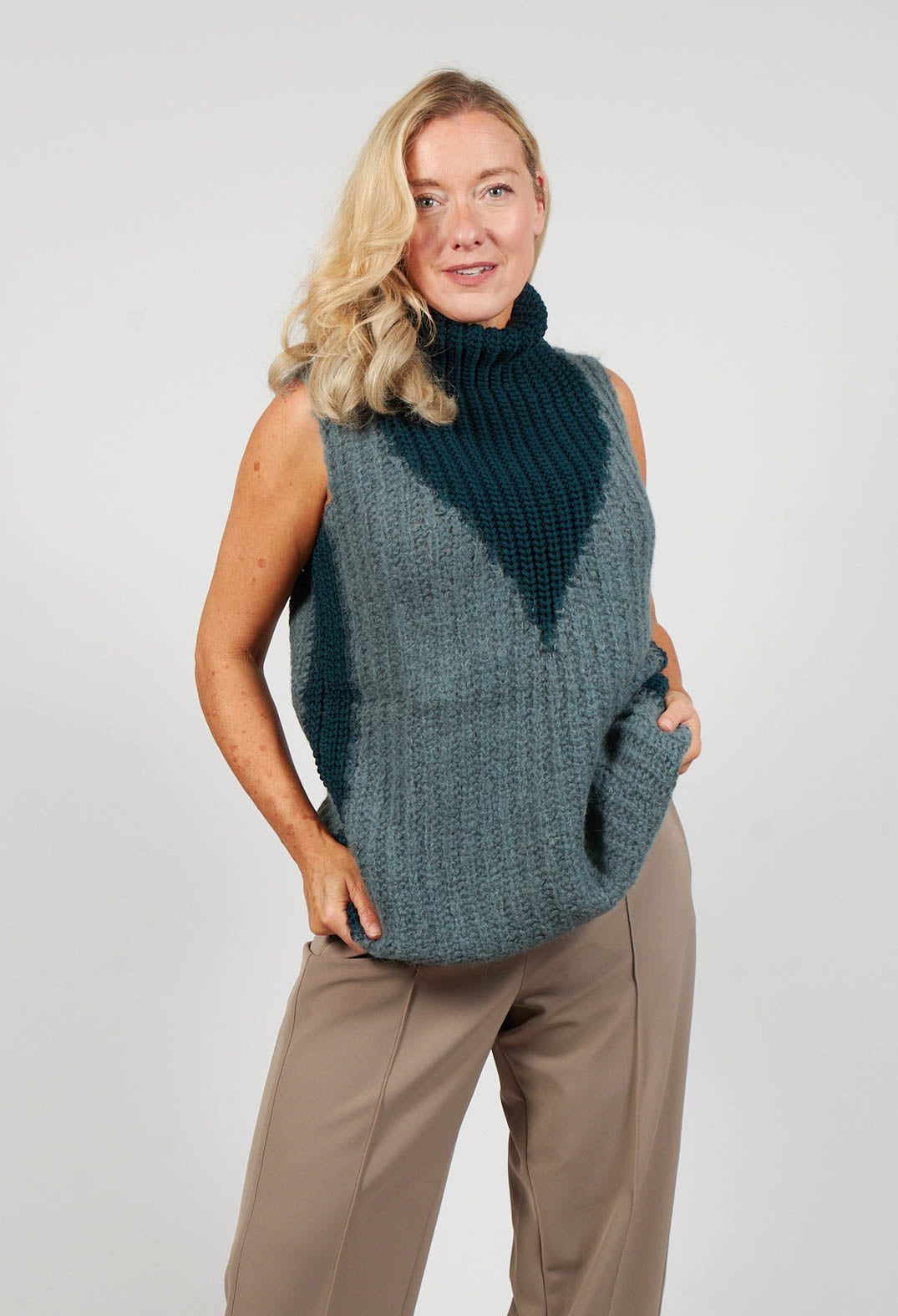 lady wearing a sleeveless knit jumper with a turtleneck in cypress shade