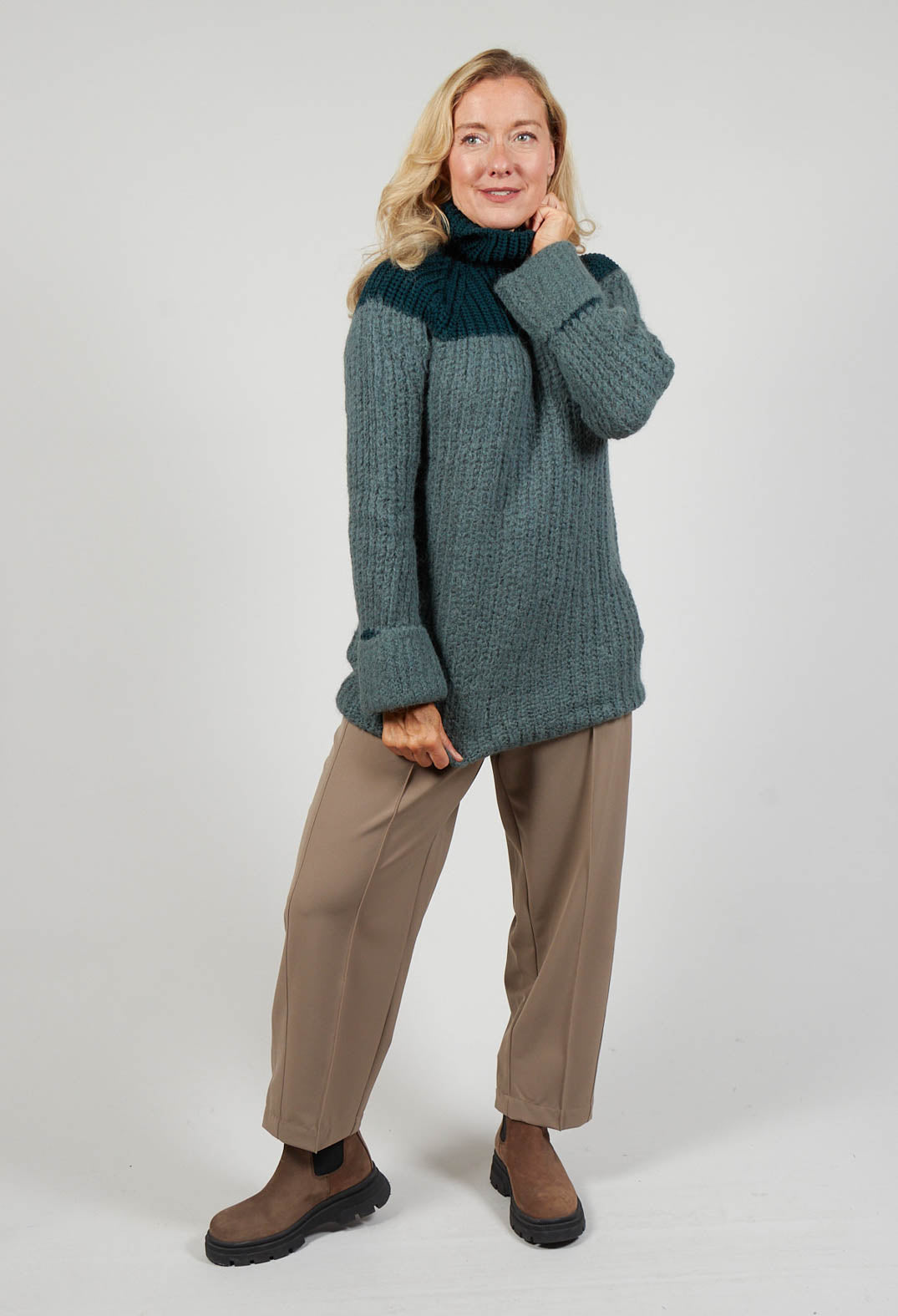 lady wearing a chunky knit jumper cypress green