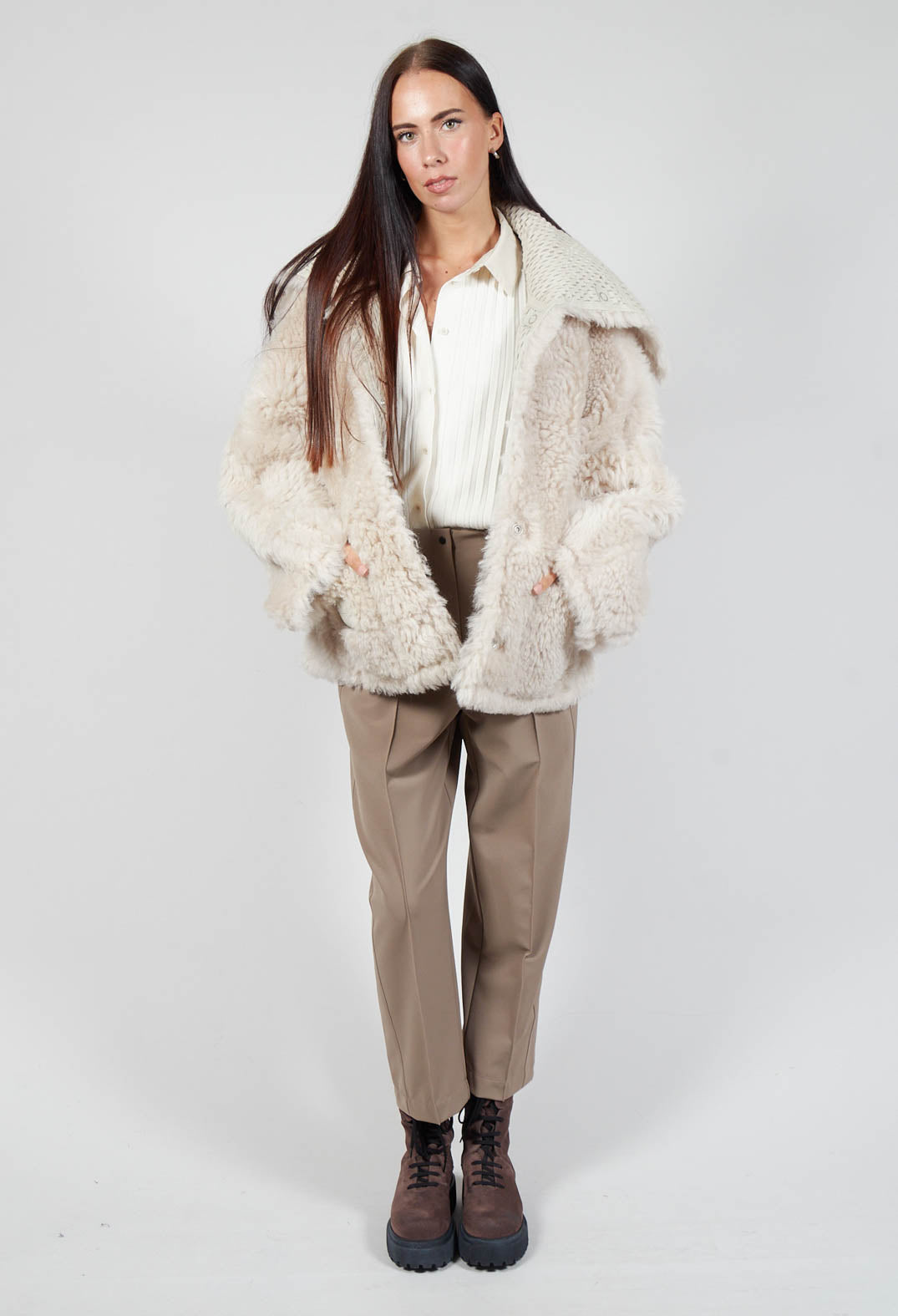 long shot of a lady wearing a mid length jacket in cream dune shade