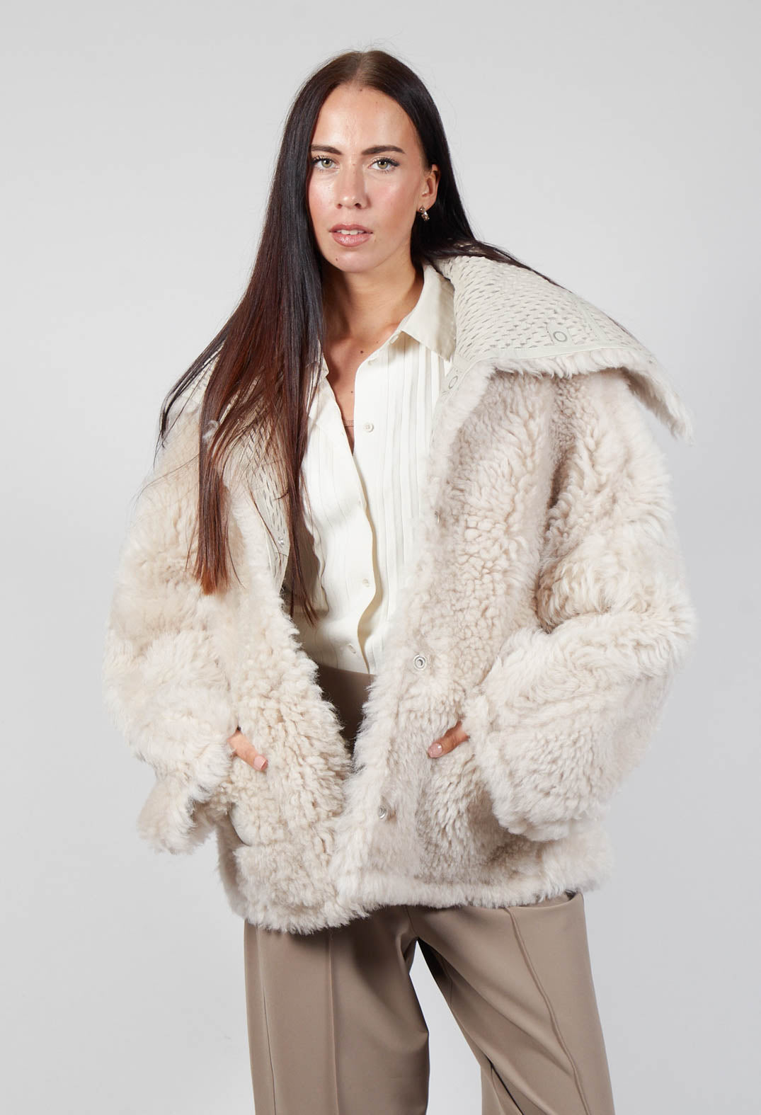 lady wearing a siro jacket in cream with light brown trousers