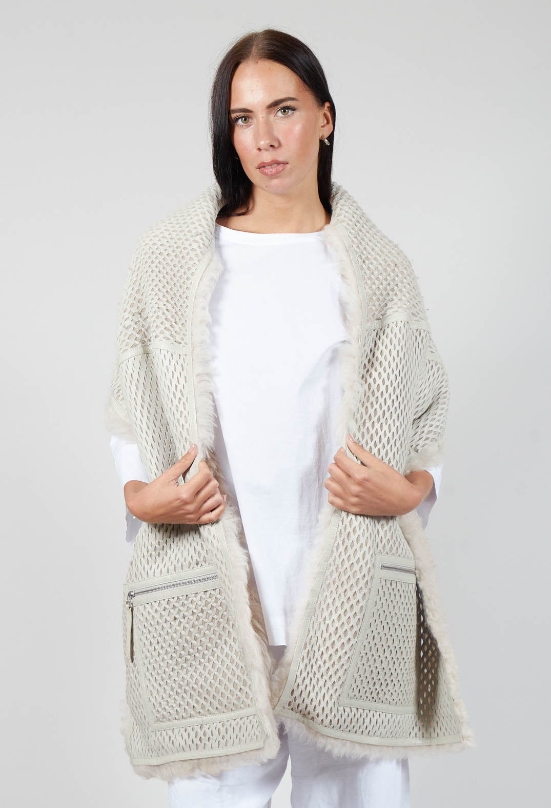 lady wearing a cream fluffy sito scarf with a mesh lining and zip pockets