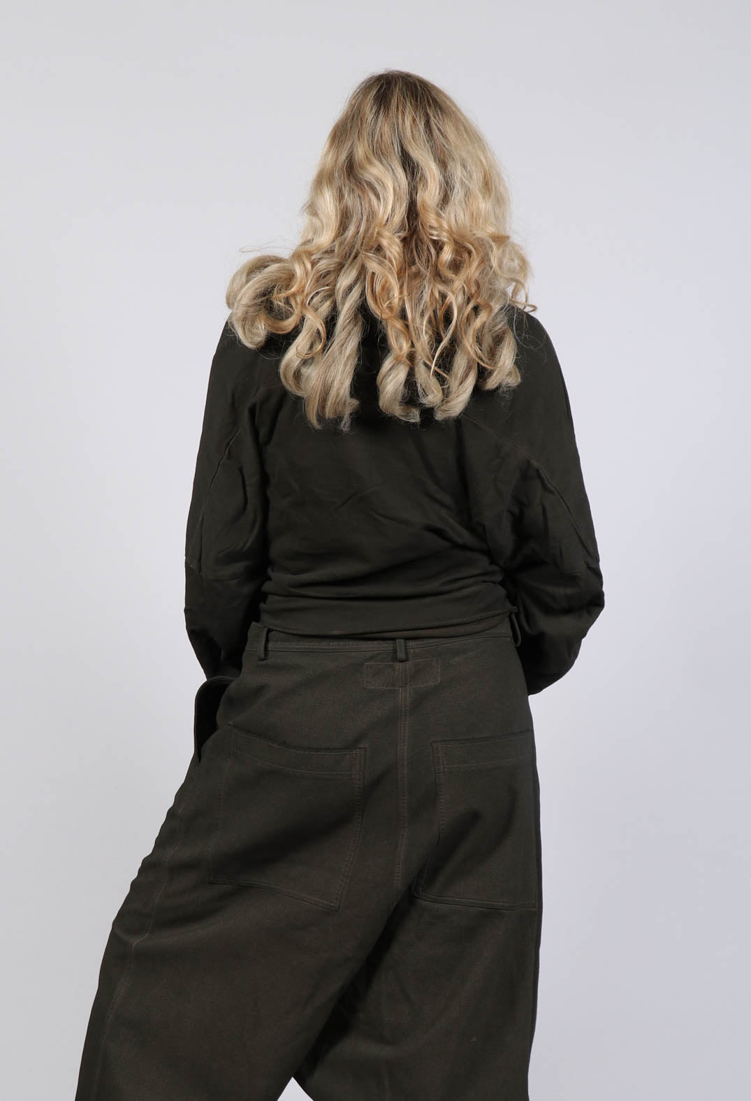 behind shot of a cropped black pullover with a wide round neck
