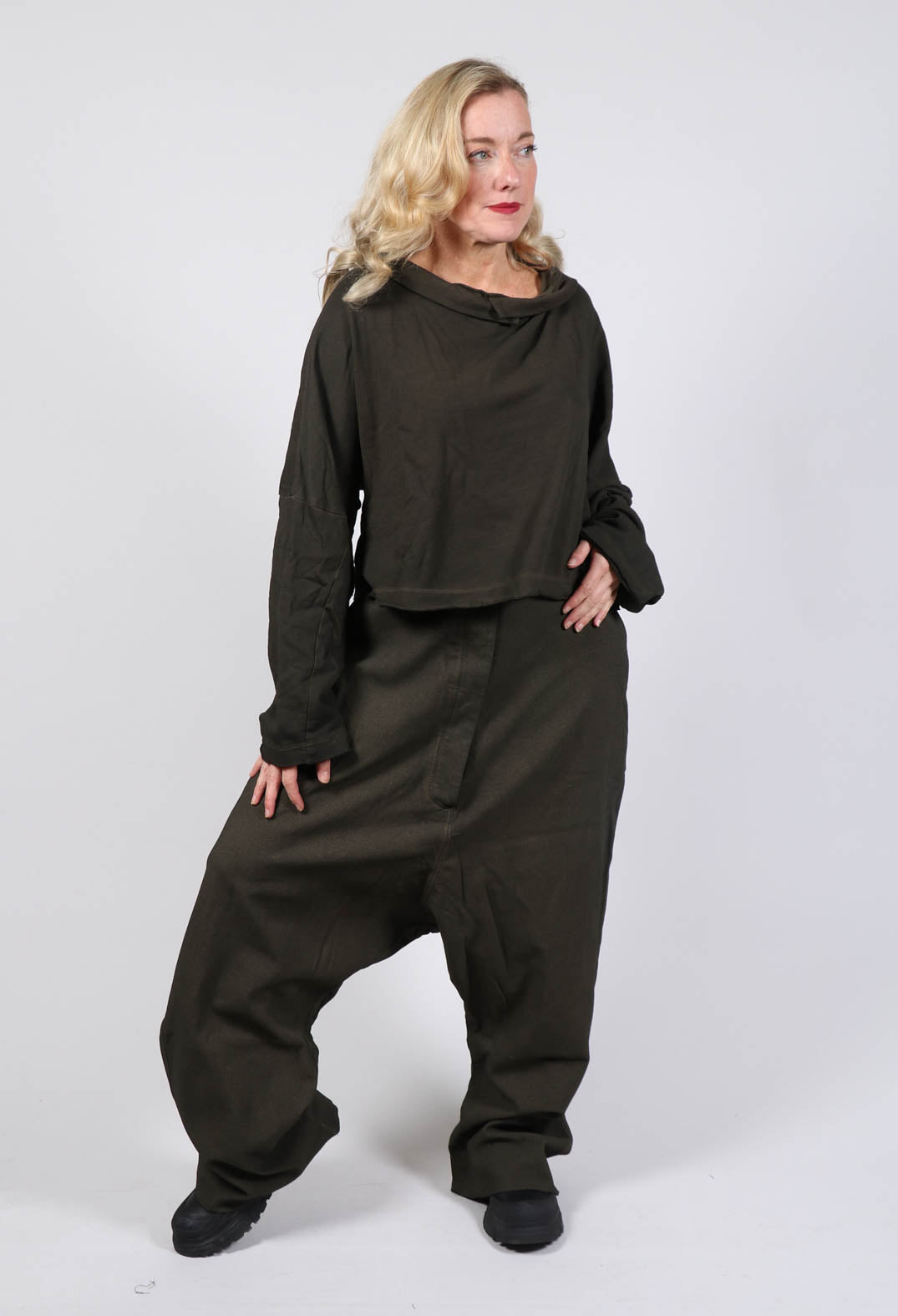 lady wearing a cropped black pullover and drop crotch trousers