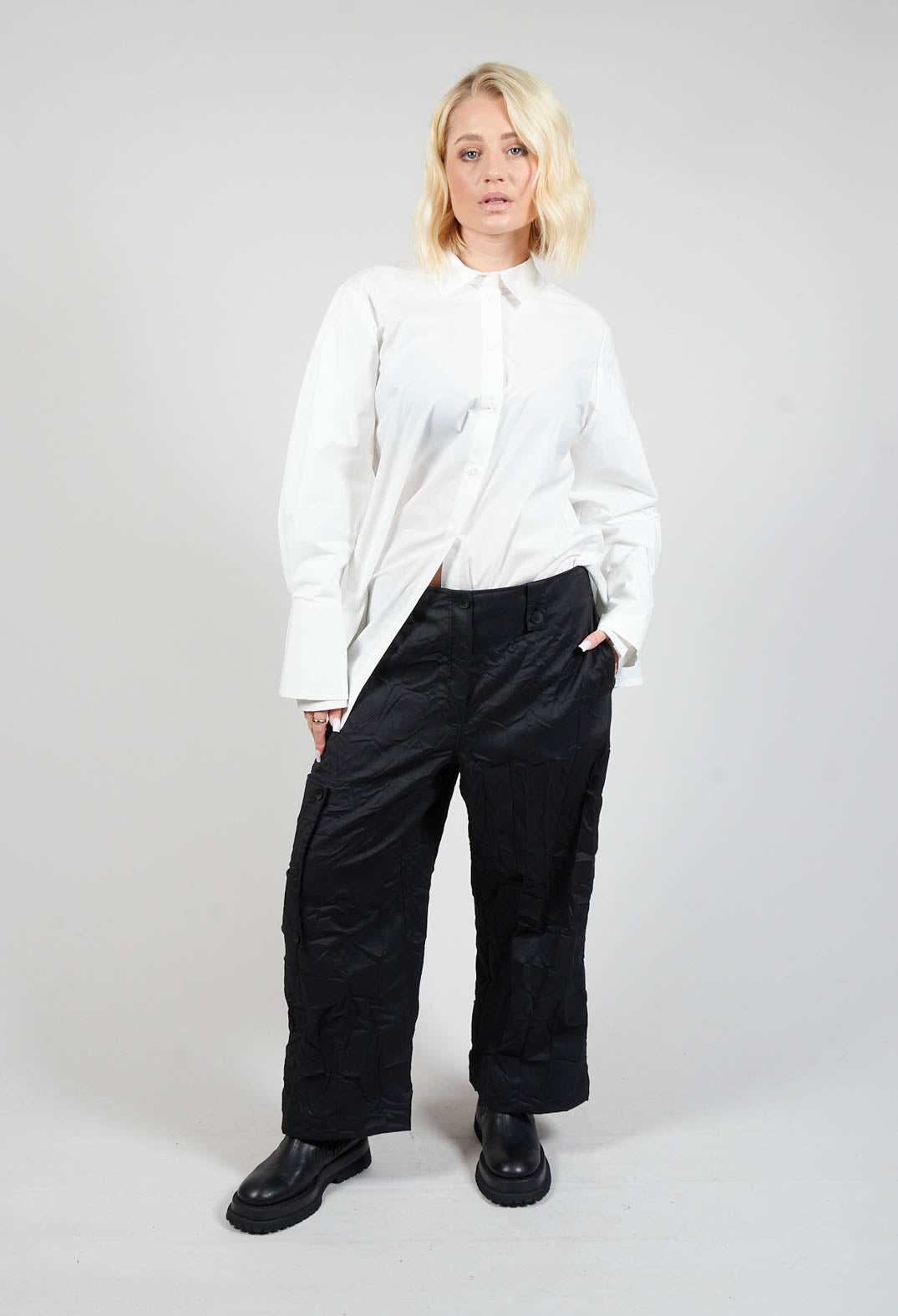 lady wearing black wide leg trousers with side pockets and chunky black boots