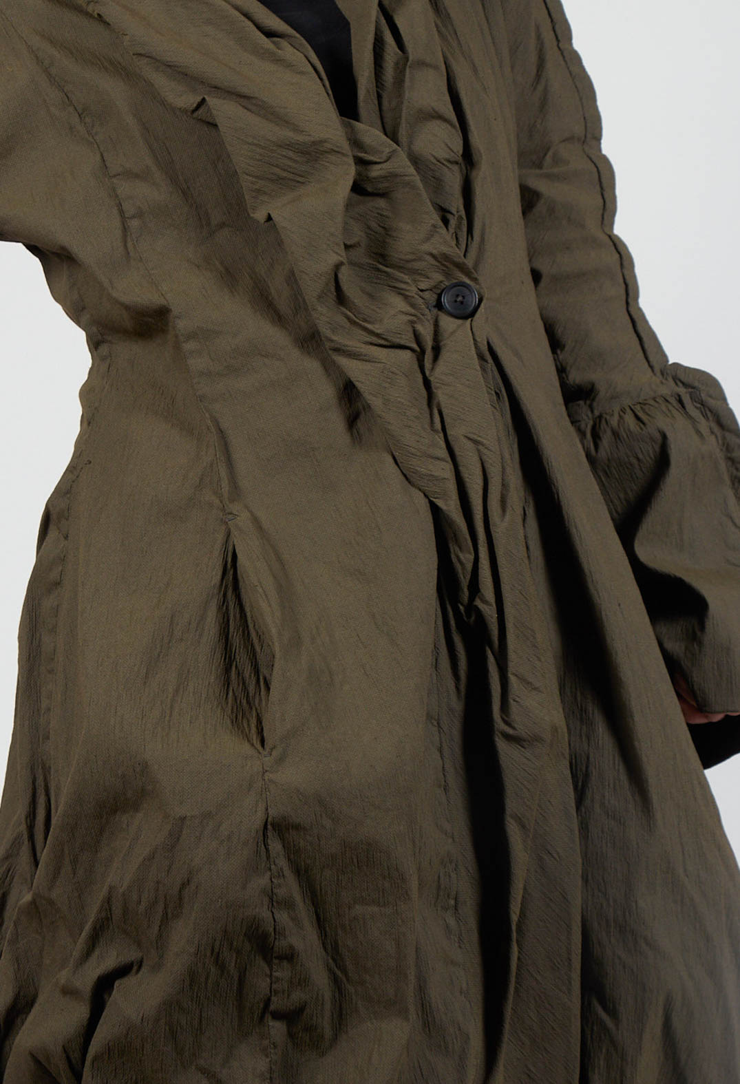 close up of a khaki coat with button detailing