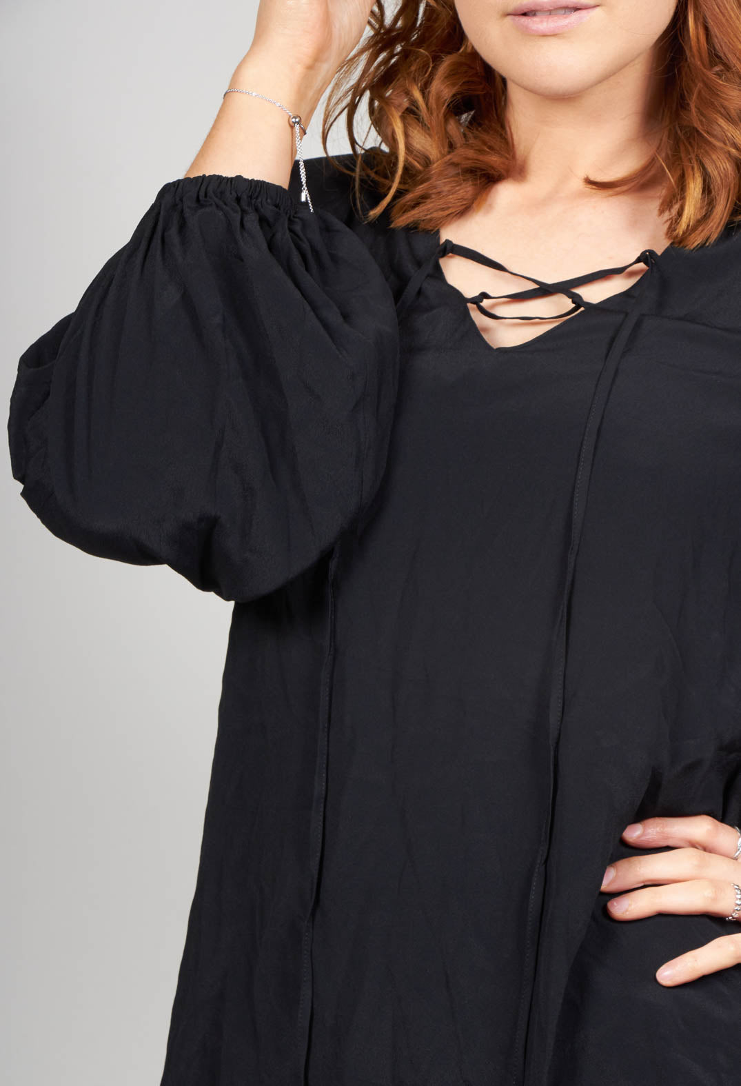 lady wearing a blouse in black with a pretty neck tie detail