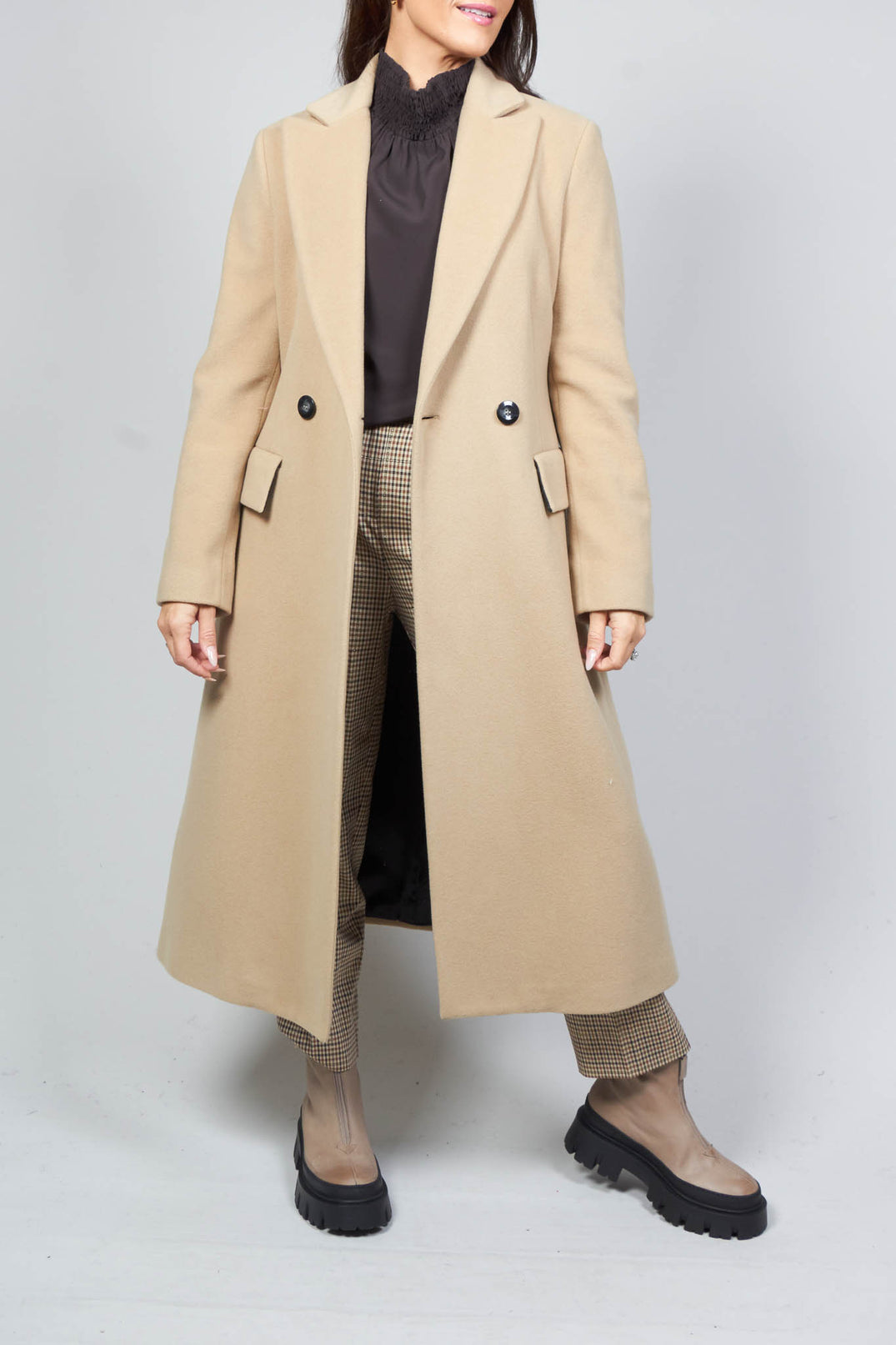 lady wearing a tailored duster coat in camel