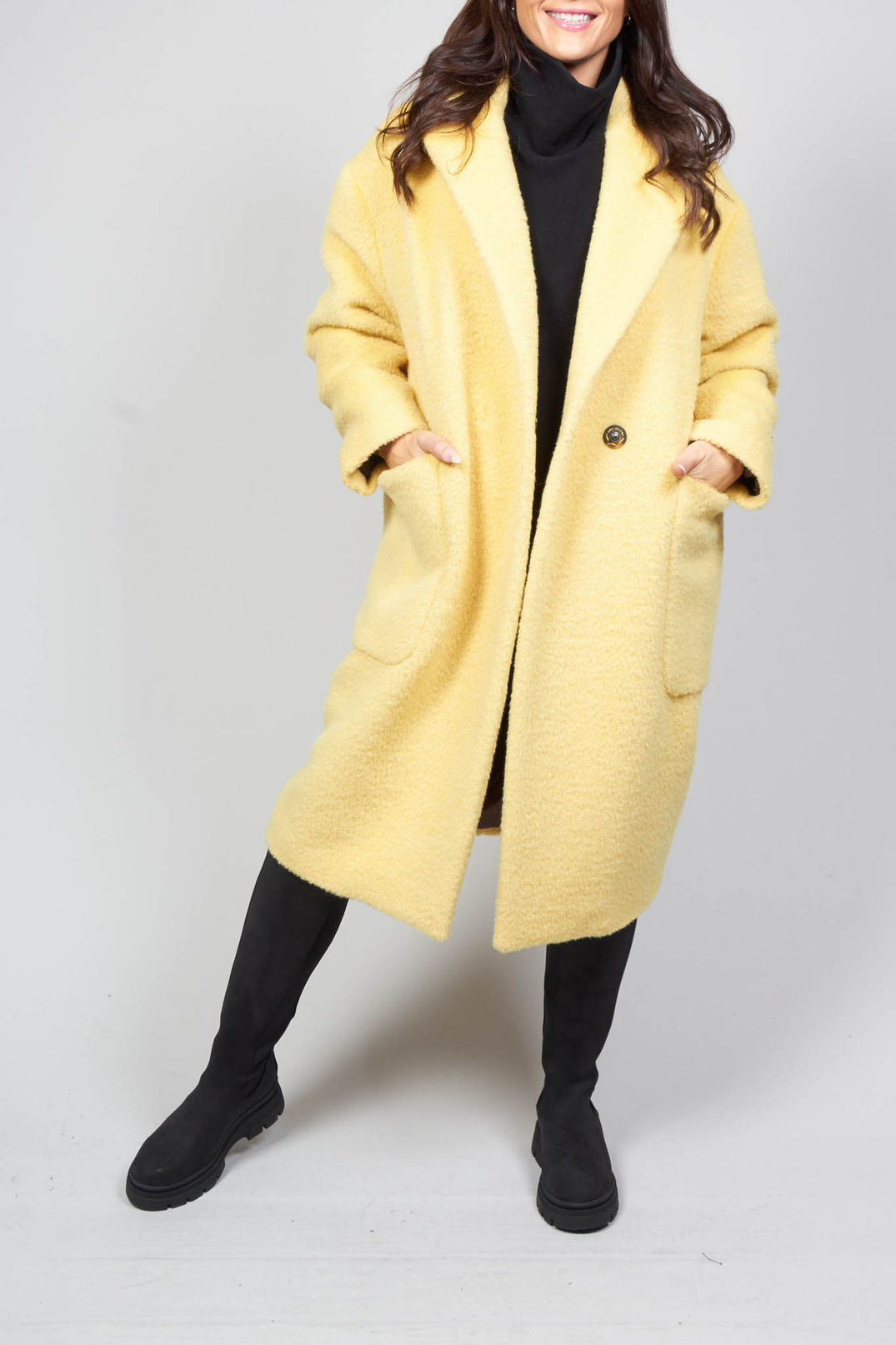 lady wearing a cream yellow longline wool coat