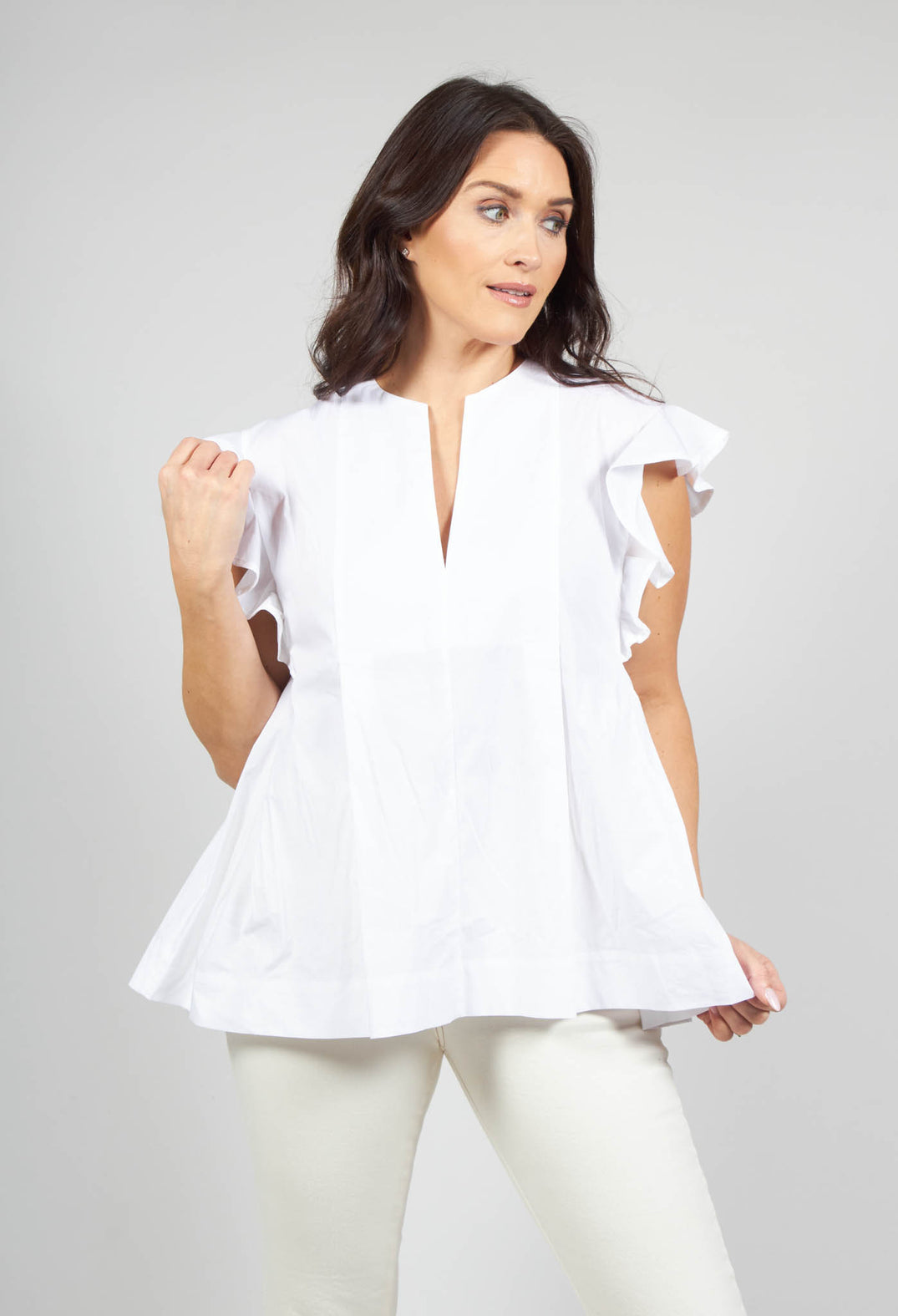 lady wearing a white v neck shirt with flounce sleeves