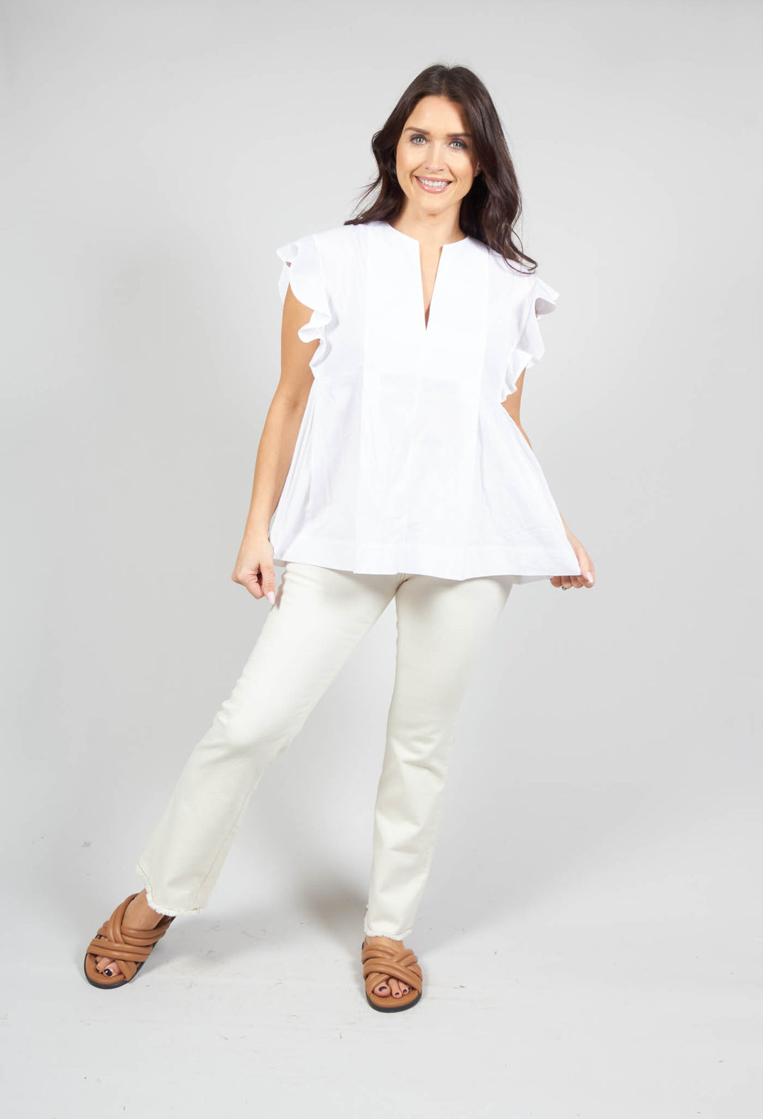happy lady wearing the white v neck shirt with flounce sleeves