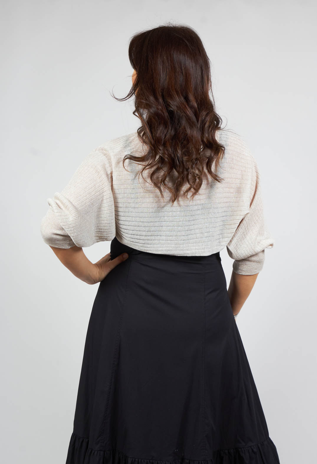 lady wearing a short balero shrug in beige with tie front
