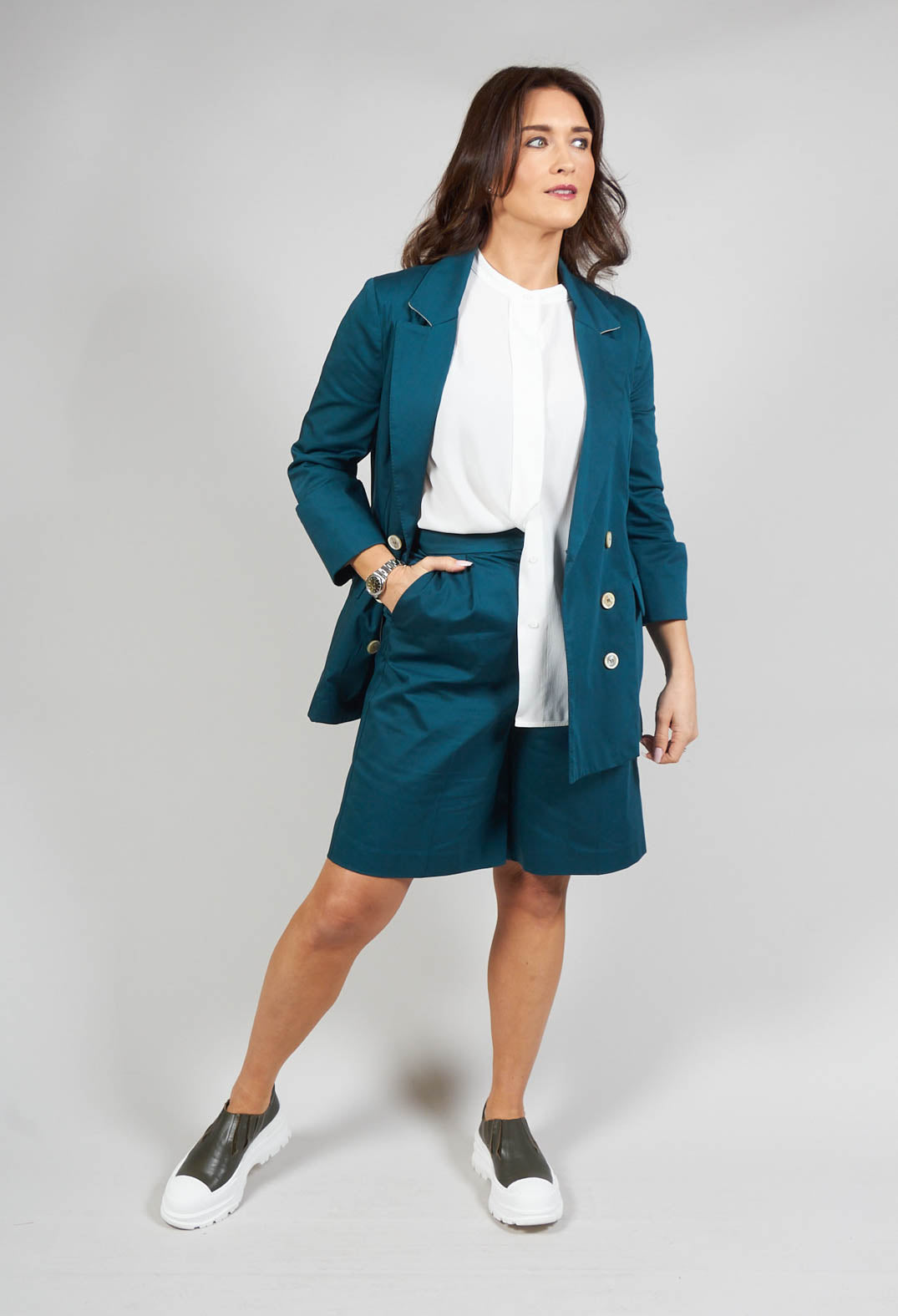 lady standing wearing bermuda tailored shorts in poseidon green