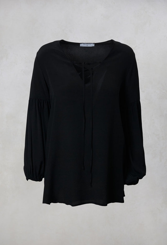 black blouse with tie neck front detail and long sleeves