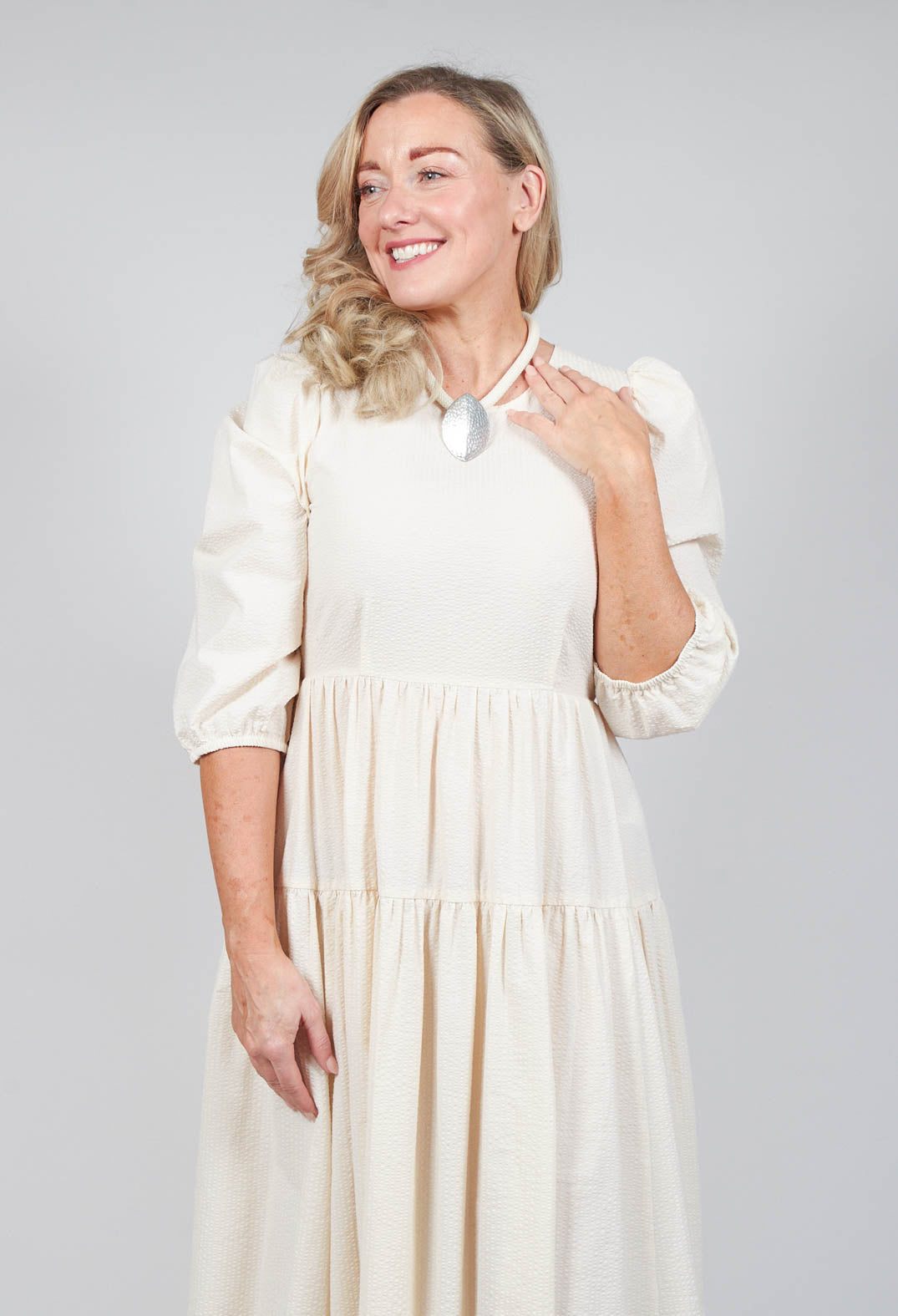 happy lady wearing beatrice b backless cream shift dress