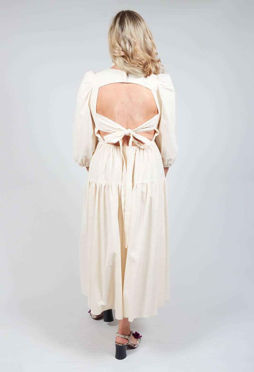 lady wearing backless cream shift dress