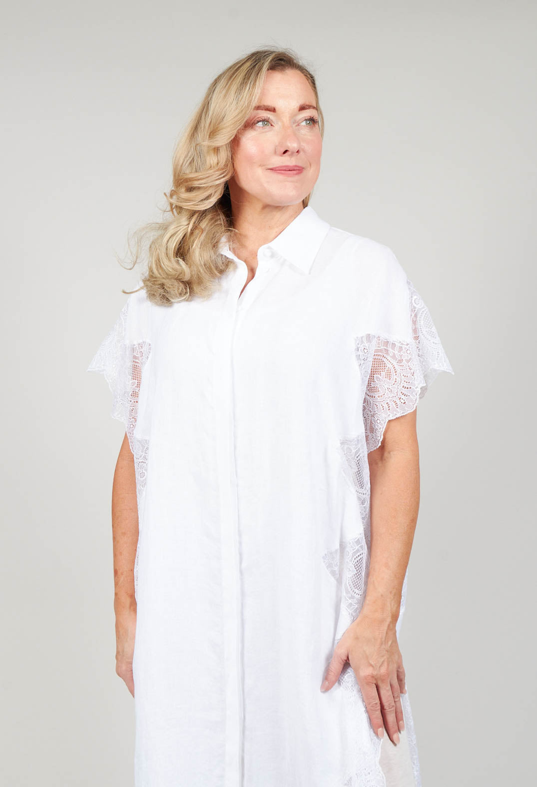 lady smiling whilst wearing the white shirt dress with lace detail
