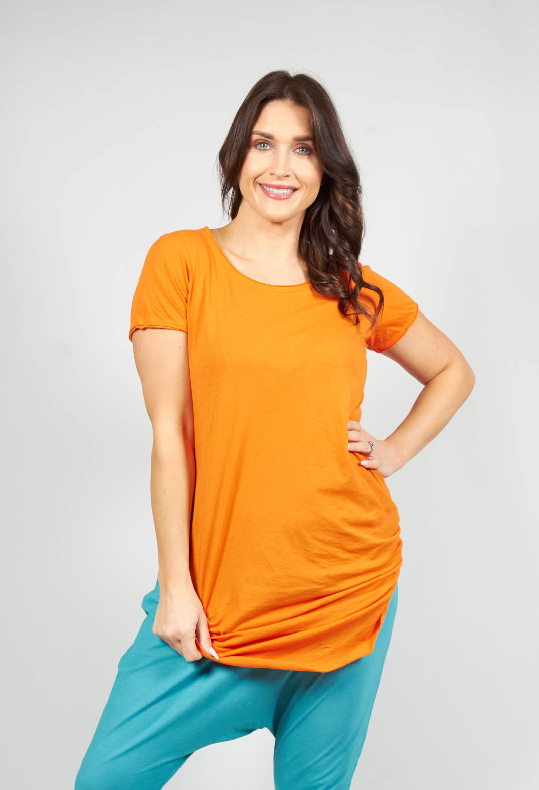 lady smiling wearing an orange long length short sleeve t shirt