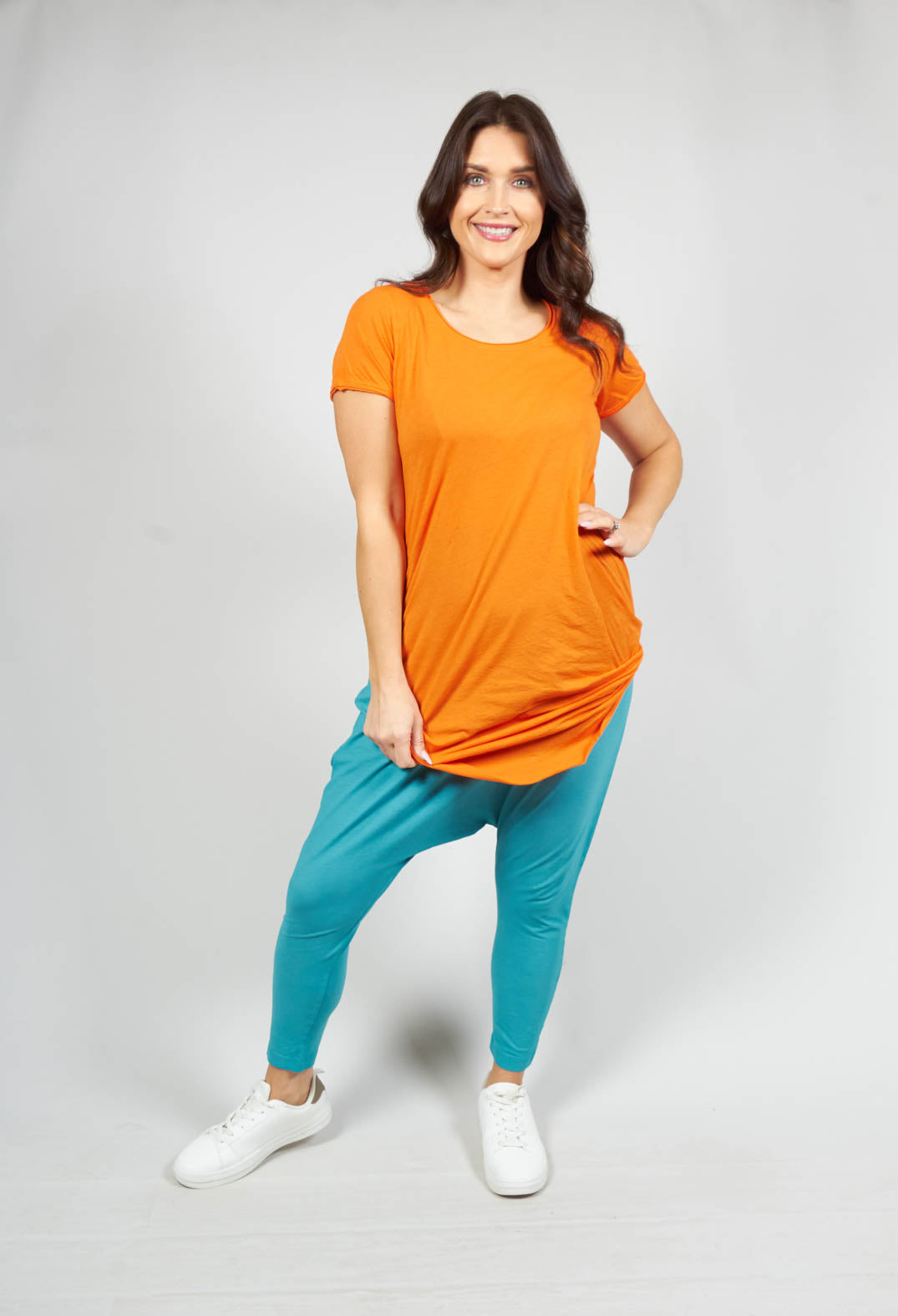 happy lady wearing a long length short sleeved t shirt in orange