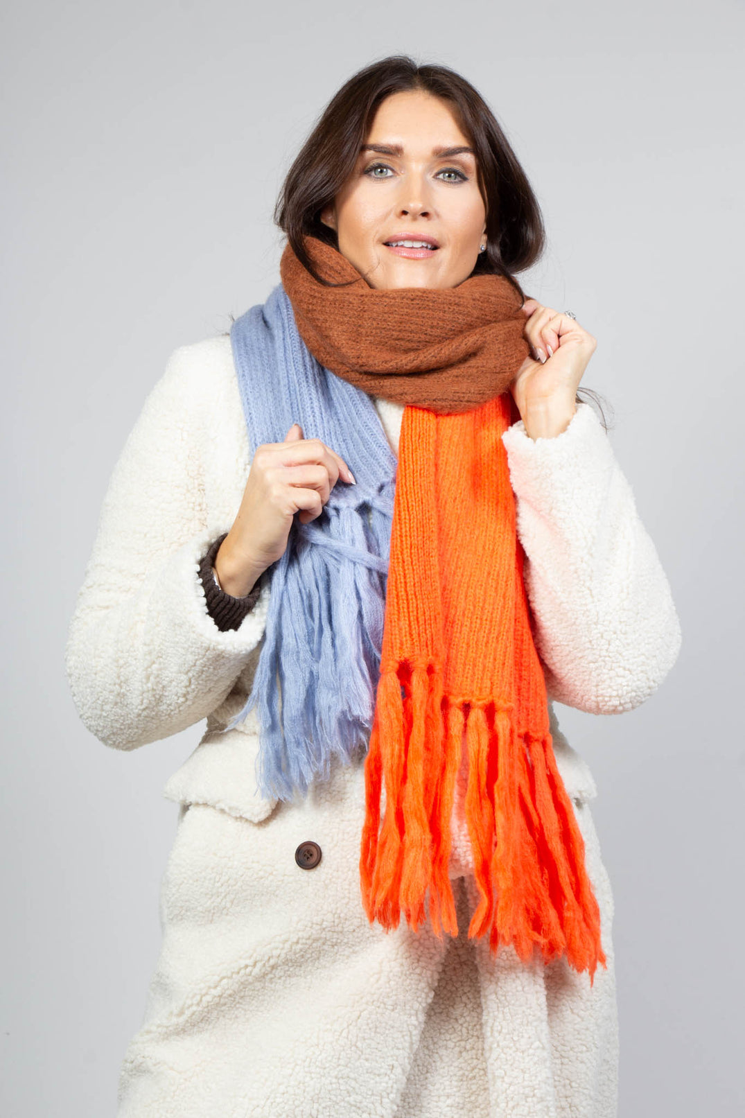 lady wearing a knitted scarf in stamina orange