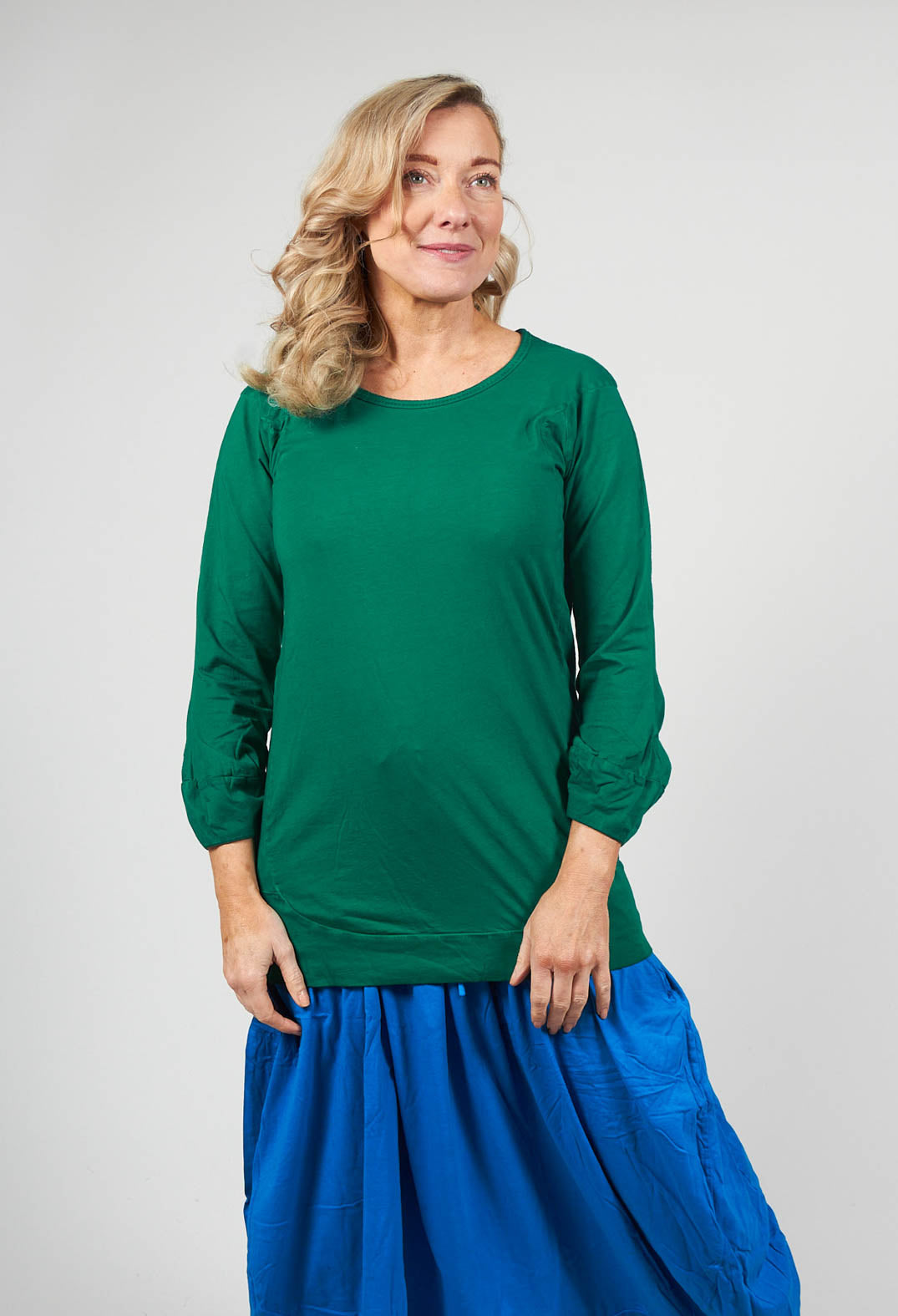 lady wearing a round neck long sleeved t shirt in green with bell sleeves