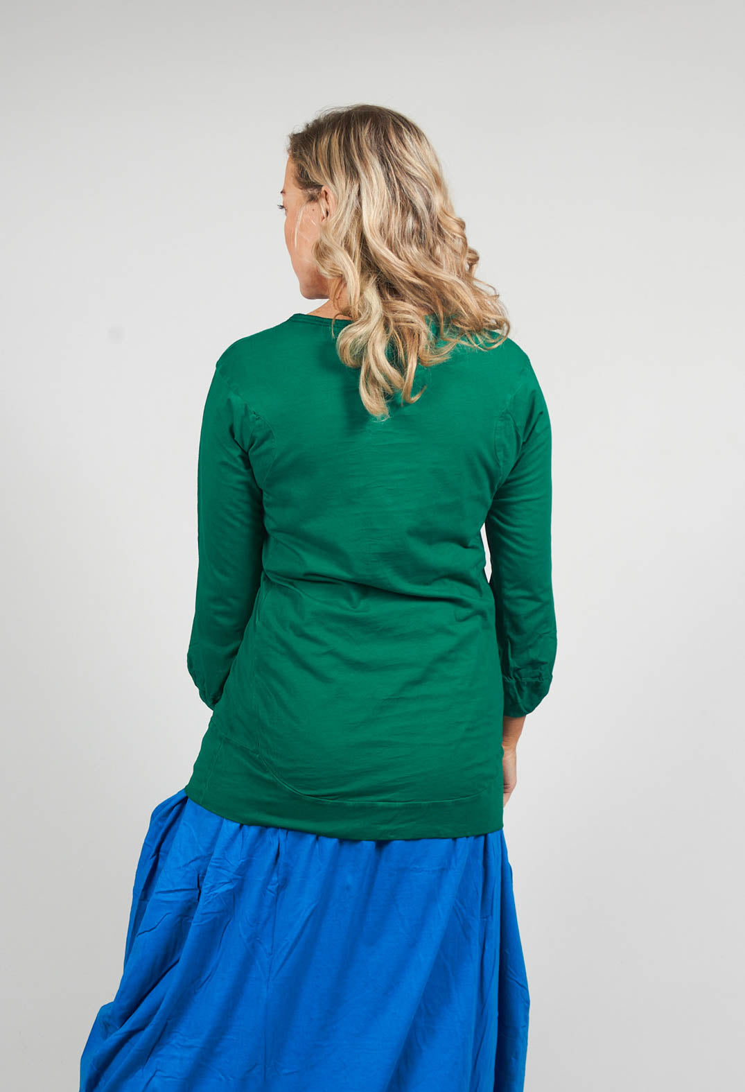 behind shot of a green long sleeved t shirt with bell sleeves