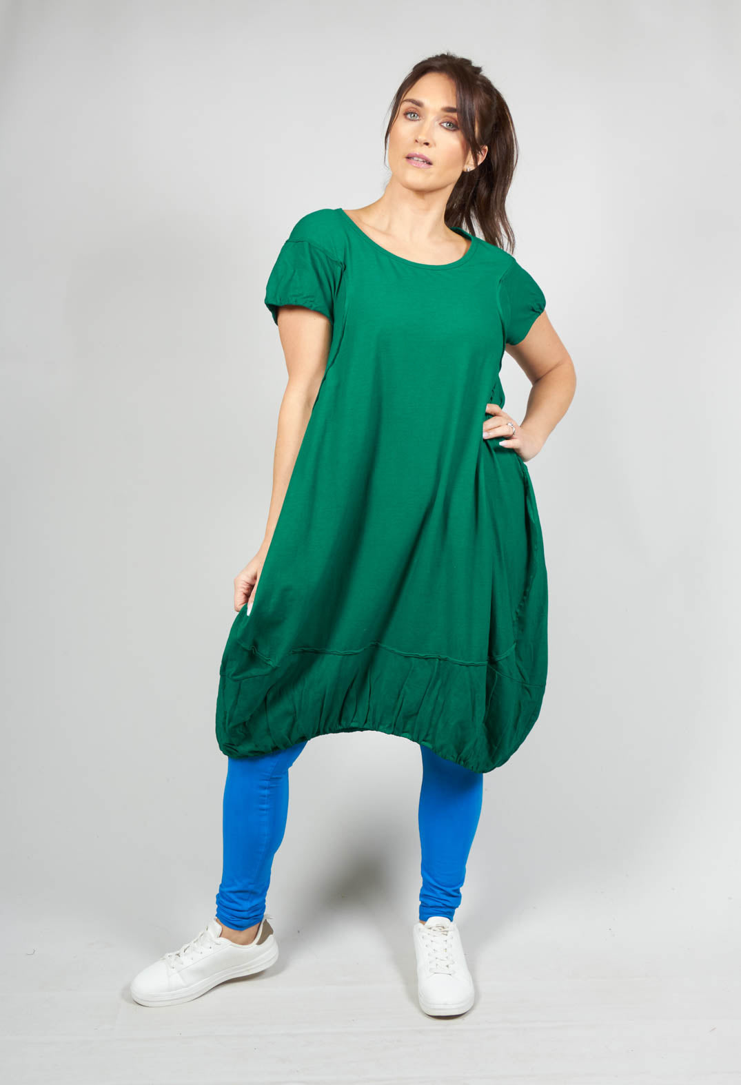 lady wearing a short sleeved jersey dress with a gathered hem in green