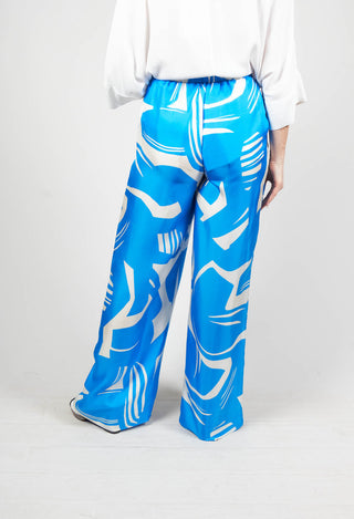 behind shot of blue macro print silk trousers