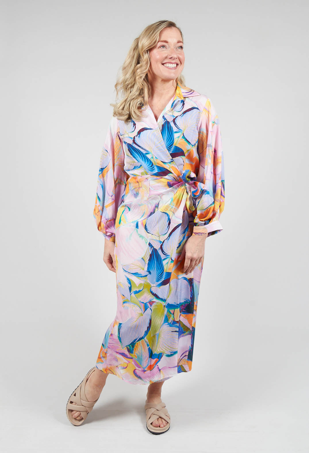 lady smiling wearing a wrap over dress in eva print