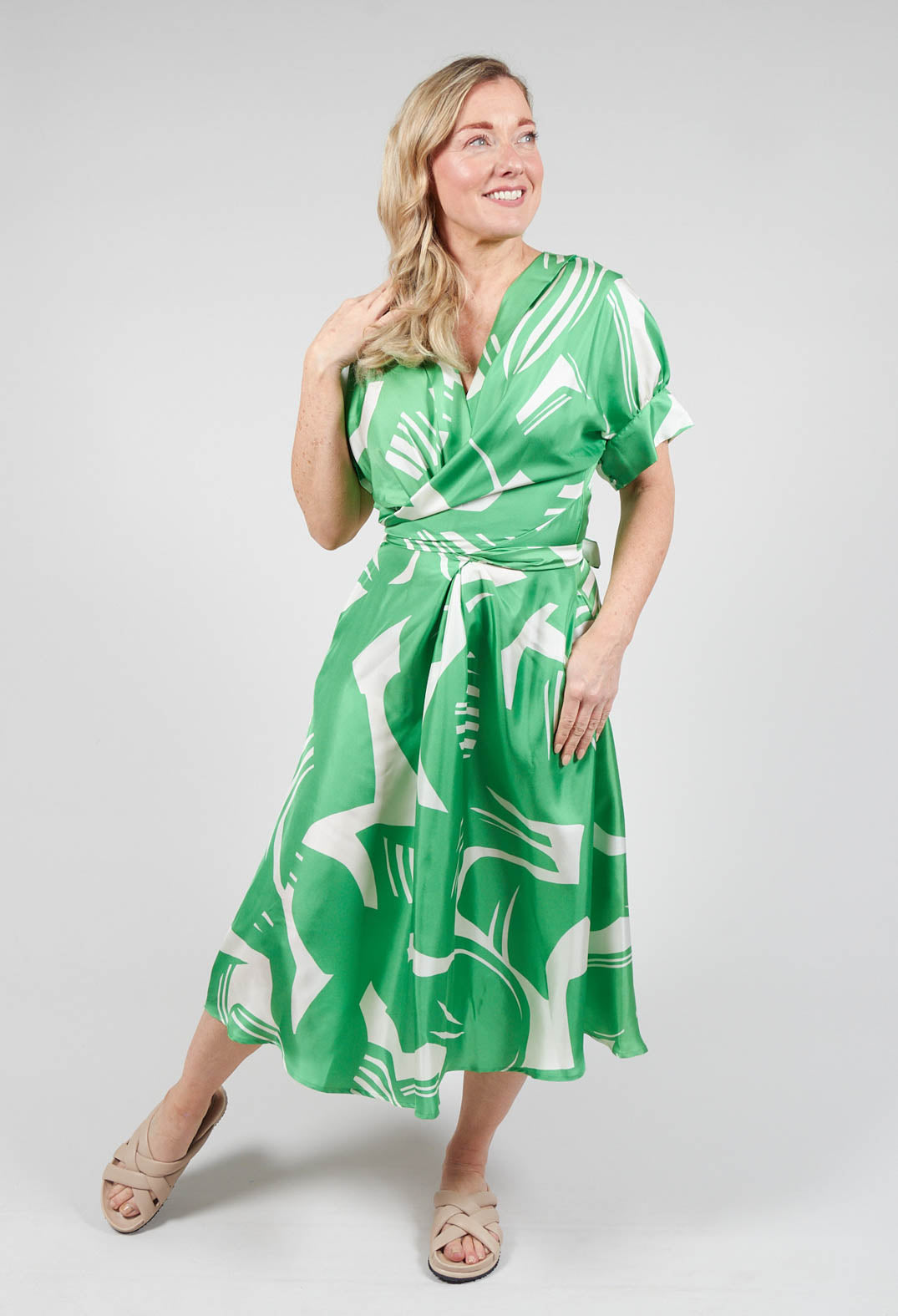 happy lady wearing a Beatrice B green wrap over silk dress